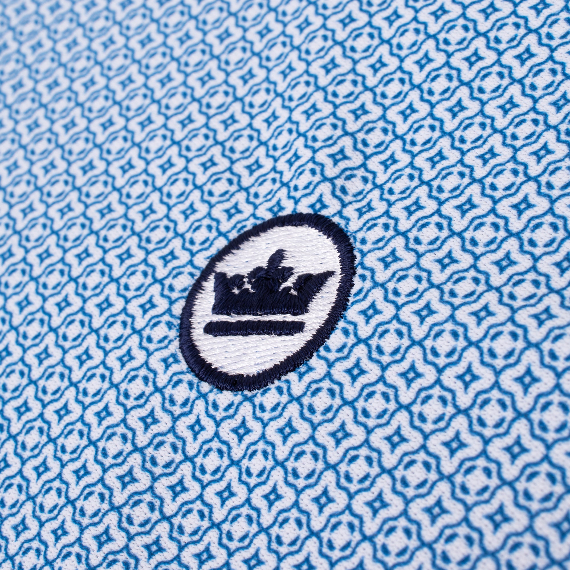 Close-up of Peter Millar logo on chest of Costa Geo Polo Shirt – luxury mens golf polo shirt UK